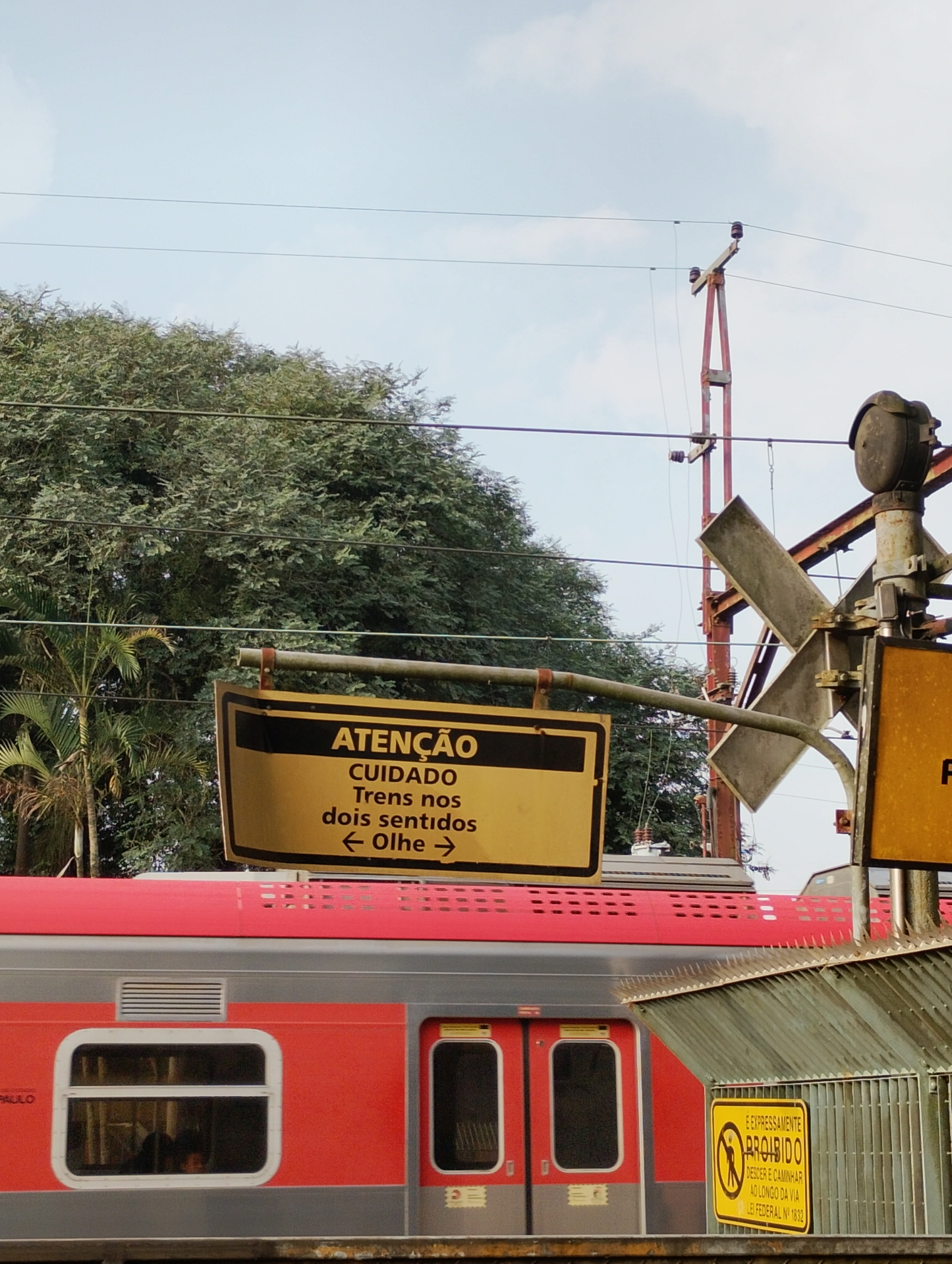 trem vermelho e placa de atenção